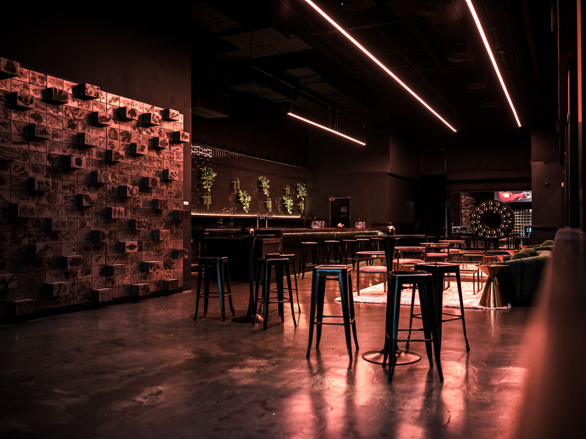 Low-lit private meeting lounge with bar seating and warm accent lighting